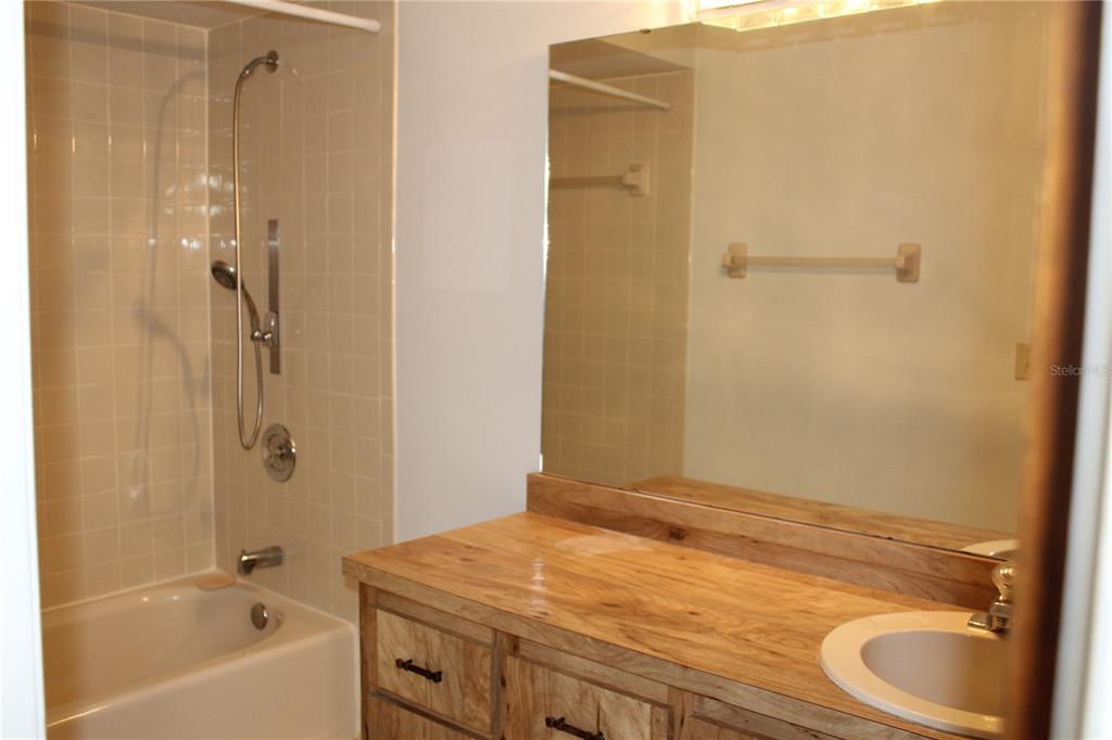 1638 Lamplighter Way Orlando, FL 32818 - Photo 14 of 25 a bathroom with a granite countertop sink a toilet and shower