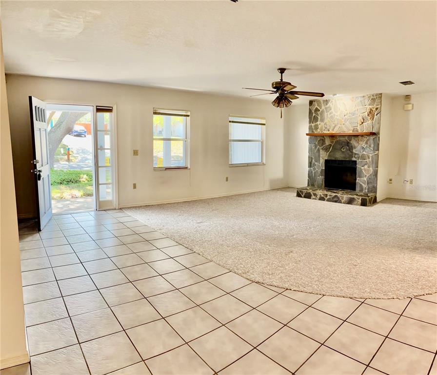1638 Lamplighter Way Orlando, FL 32818 - Photo 4 of 25 a view of a livingroom with a fireplace a chandelier and windows