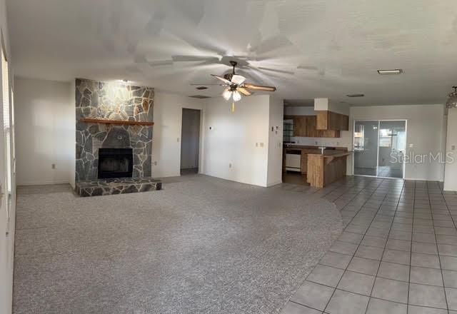 1638 Lamplighter Way Orlando, FL 32818 - Photo 8 of 25 a view of a livingroom with a fireplace a chandelier fan and windows
