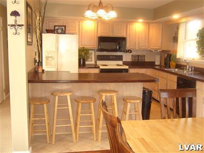 202 Ruth Road Bath, PA 18014 - Photo 6 of 10 a kitchen with stainless steel appliances kitchen island granite countertop a sink and cabinets