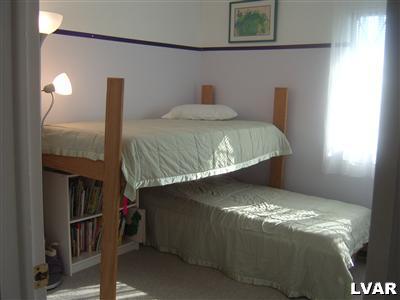 202 Ruth Road Bath, PA 18014 - Photo 8 of 10 a bed sitting in a bedroom next to a lamp