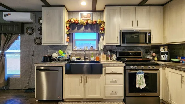 a kitchen with granite countertop a stove and a microwave