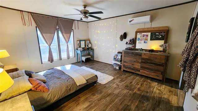 a bedroom with a bed next to a window with the flat screen tv