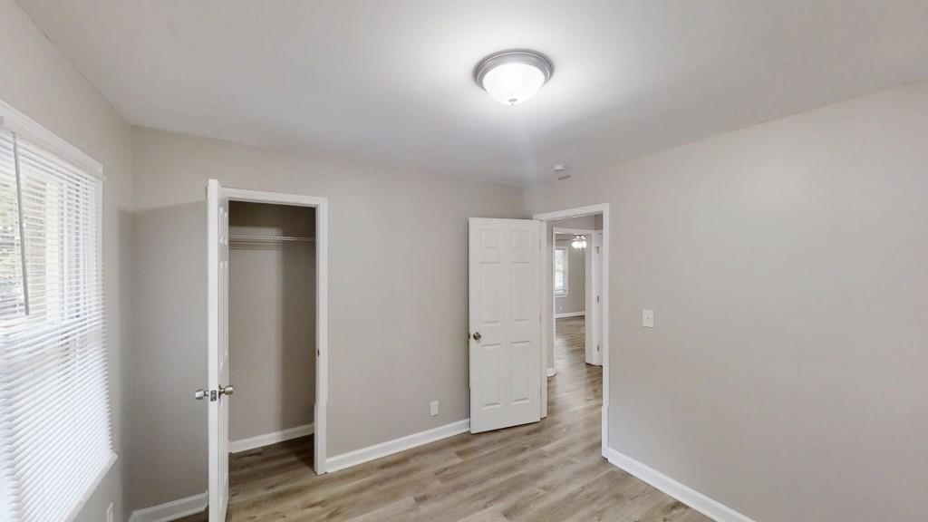 568 McWilliams Road Southeast Atlanta, GA 30315 - Photo 13 of 17 an empty room with wooden floor and windows