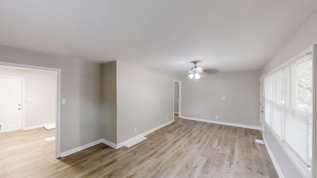 568 McWilliams Road Southeast Atlanta, GA 30315 - Photo 3 of 17 an empty room with wooden floor ceiling fan and window
