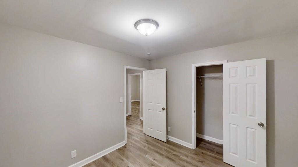 568 McWilliams Road Southeast Atlanta, GA 30315 - Photo 8 of 17 an empty room with wooden floor and windows