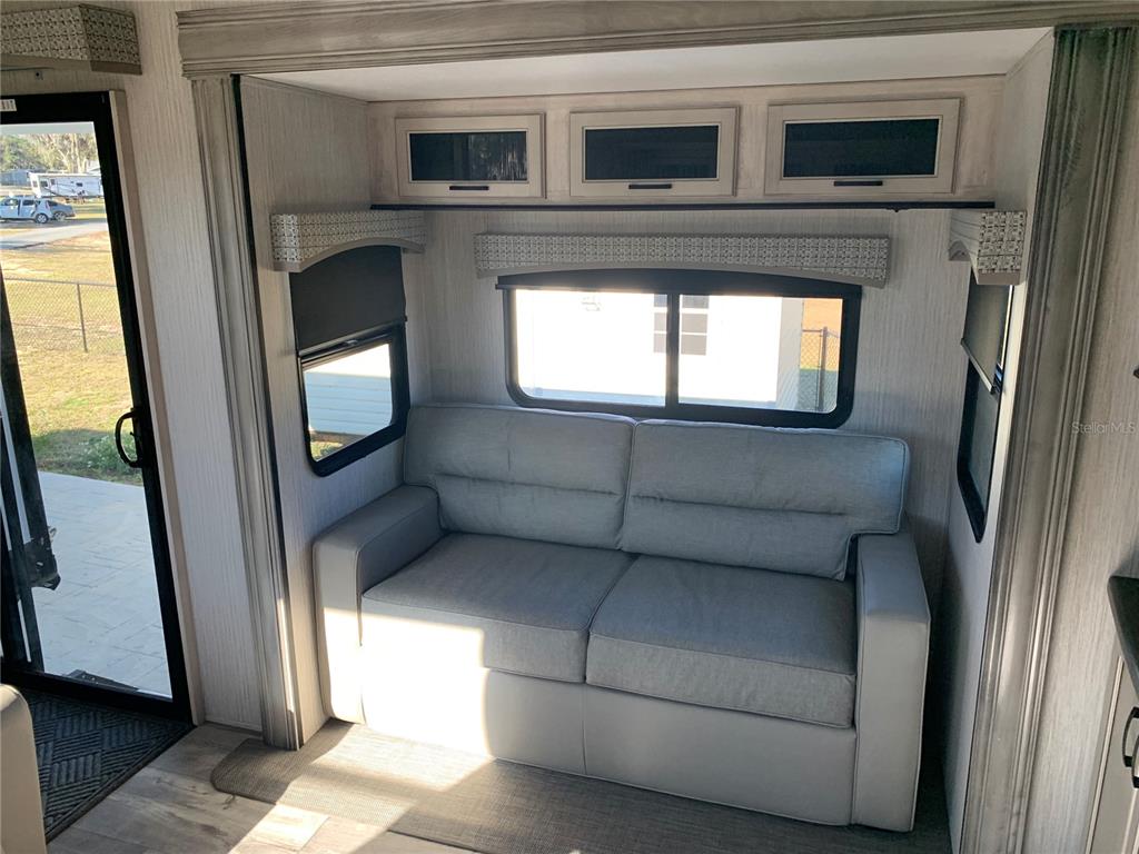 15991 Northeast 243rd Place Road, Unit 143 Fort McCoy, FL 32134 - Photo 11 of 35 a living room with a large window and a fireplace