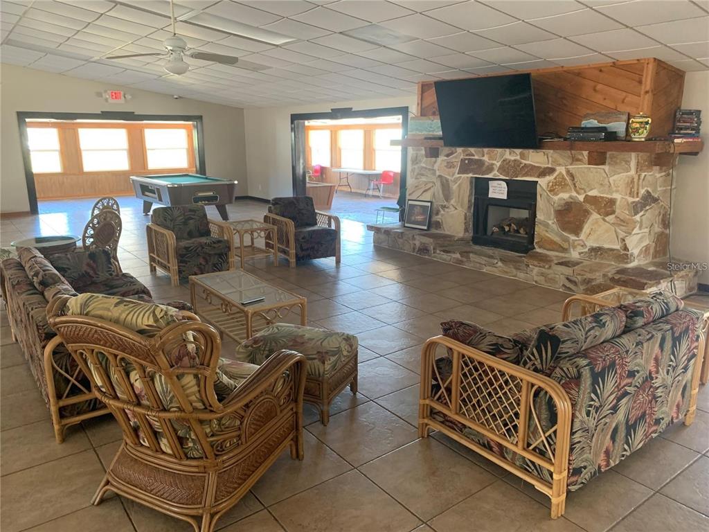 15991 Northeast 243rd Place Road, Unit 143 Fort McCoy, FL 32134 - Photo 25 of 35 a living room with furniture a flat screen tv and a fireplace
