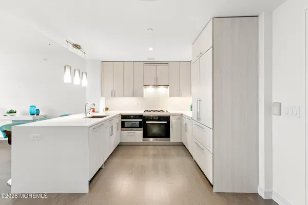 a large white kitchen with a stove a sink and a refrigerator