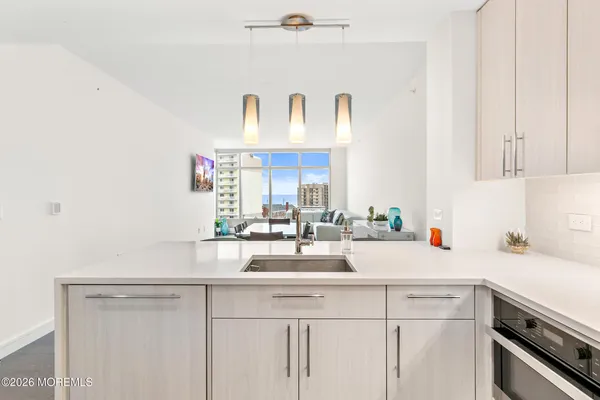 a kitchen with kitchen island a sink a stove and cabinets