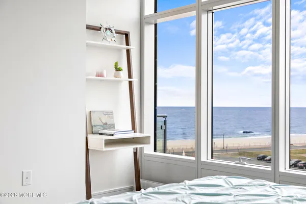a view of a living room with a bed furniture and floor to ceiling window