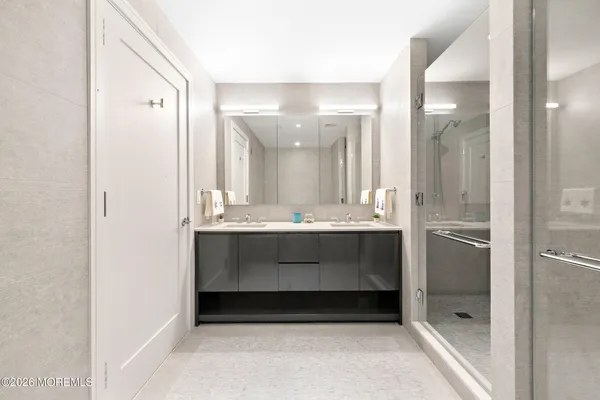 a bathroom with a shower sink and mirror
