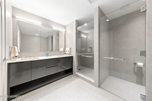 a bathroom with a double vanity sink mirror and shower