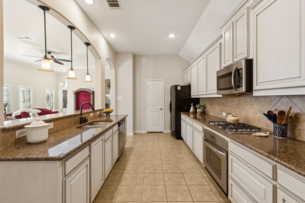 1805 Harlequin Place Allen, TX 75002 - Photo 15 of 33 Granite countertops and tile backsplash enhance this kitchen! Other features include light colored cabinetry, gas cooktop and nice size walk in pantry.