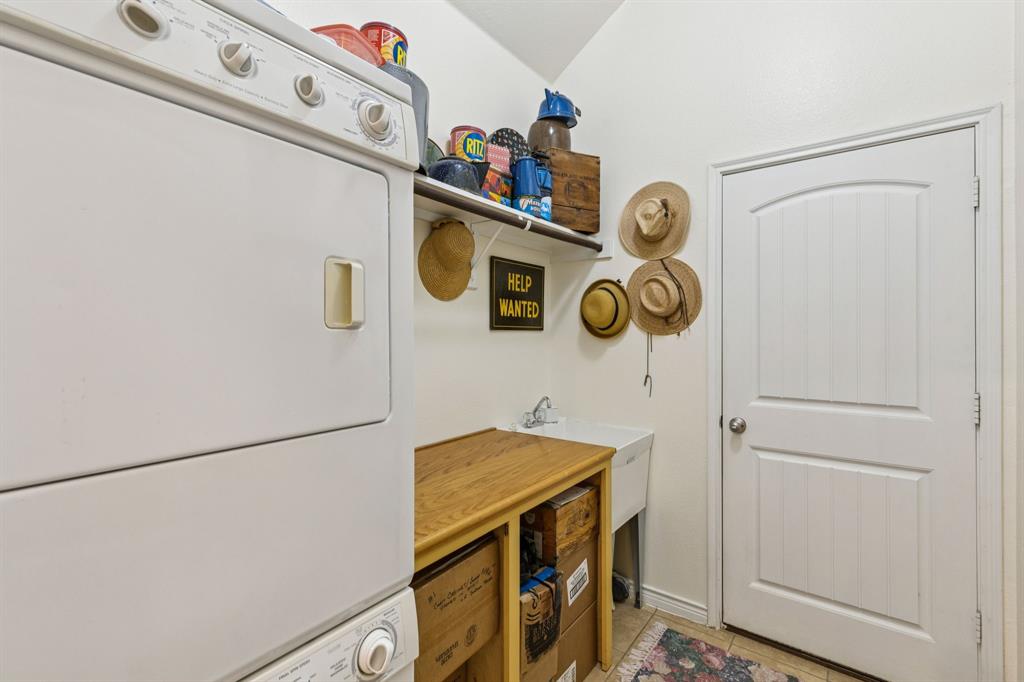 1805 Harlequin Place Allen, TX 75002 - Photo 33 of 33 Nice size utility room has sink, folding table, hanging bar and is currently configured for stackable washer and dryer.