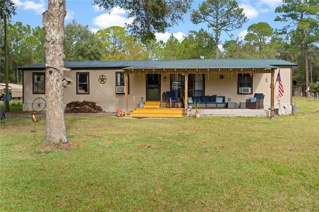 a view of a house with backyard and sitting area
