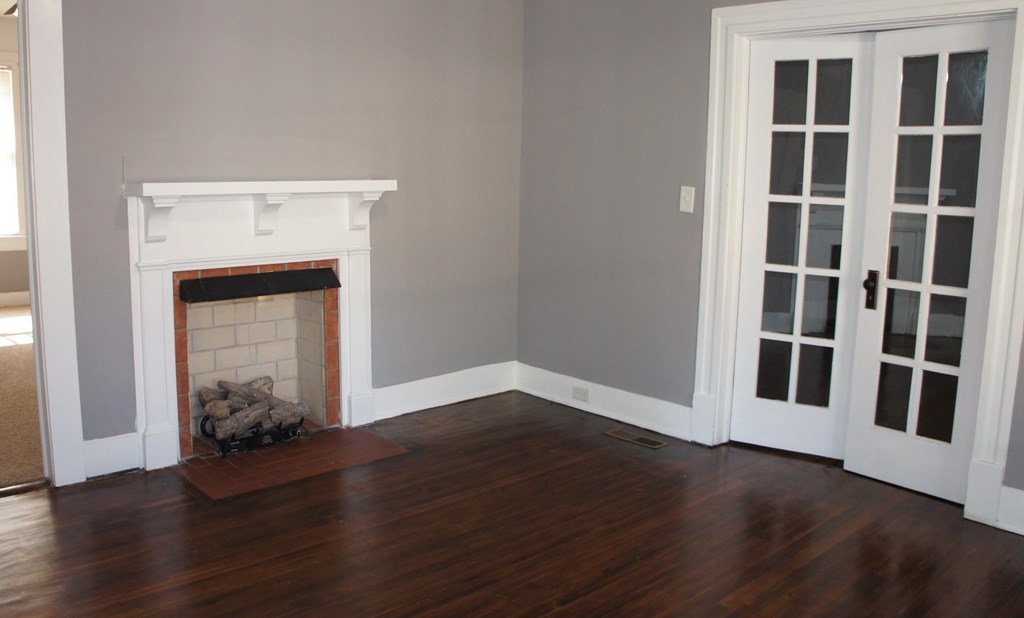 1336 19th Street Columbus, GA 31901 - Photo 2 of 20 a view of an empty room with wooden floor and a window