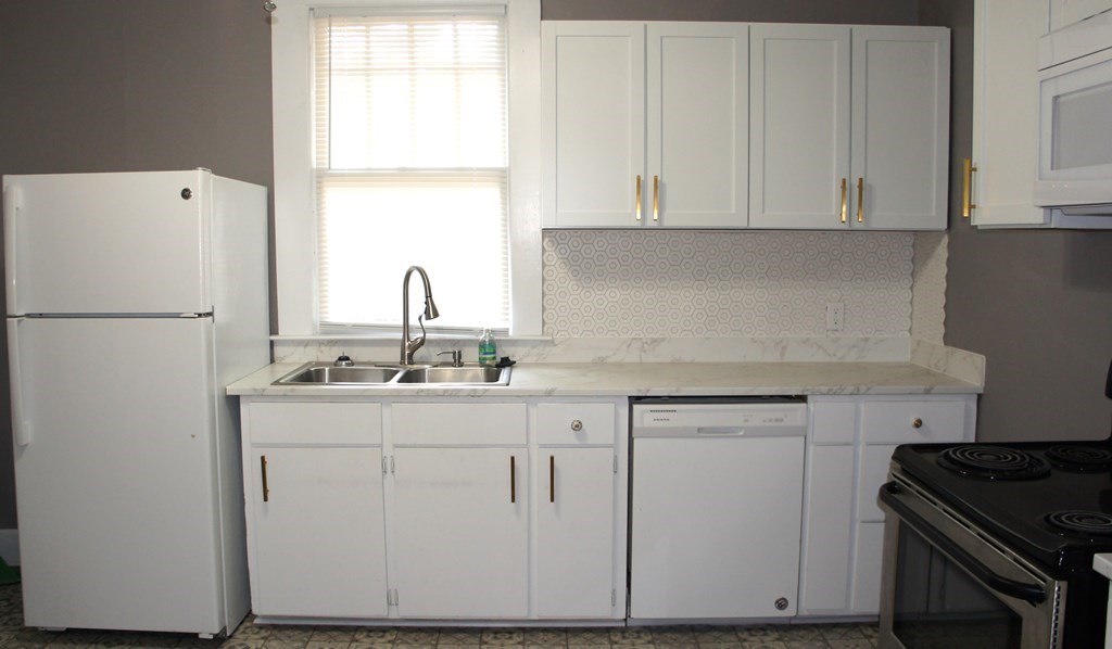 1336 19th Street Columbus, GA 31901 - Photo 5 of 20 a kitchen with white cabinets and white appliances