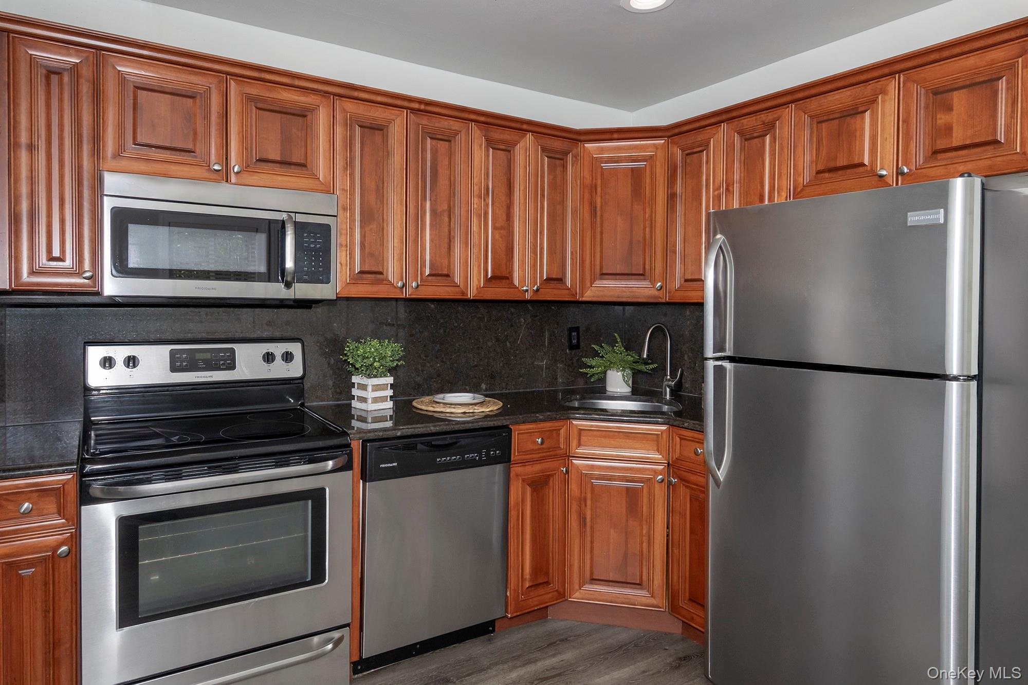70 Middleton Road, Unit SF05 Bohemia, NY 11716 - Photo 3 of 9 a kitchen with stainless steel appliances granite countertop a refrigerator stove and sink