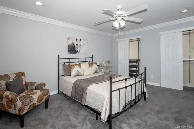 a bedroom with a bed couch ceiling fan and a window