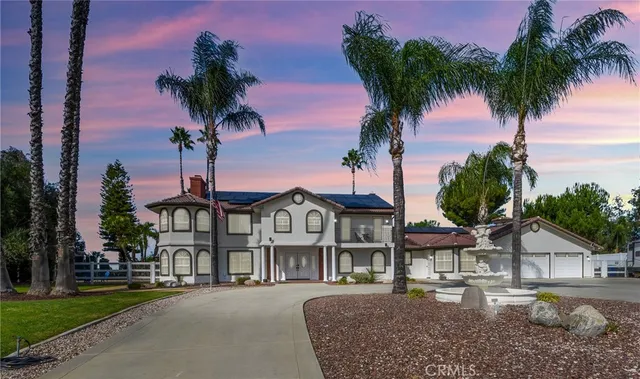 a front view of a house with balcony and garden