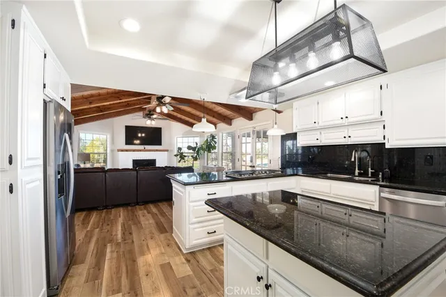 a kitchen with stainless steel appliances kitchen island granite countertop a sink and cabinets