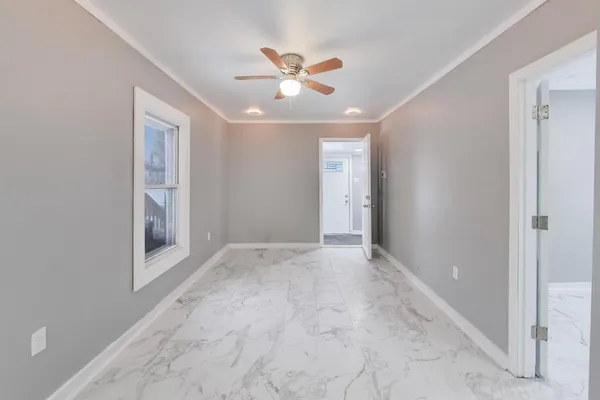 a view of an empty room with a ceiling fan
