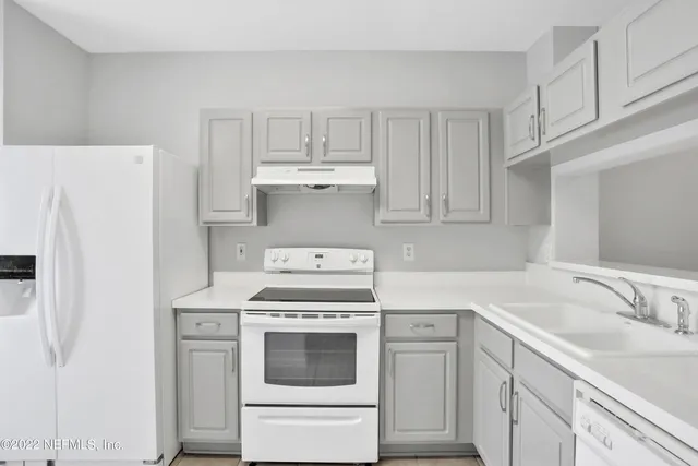 a kitchen with cabinets appliances and a sink