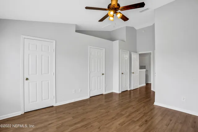 a view of an empty room with wooden floor