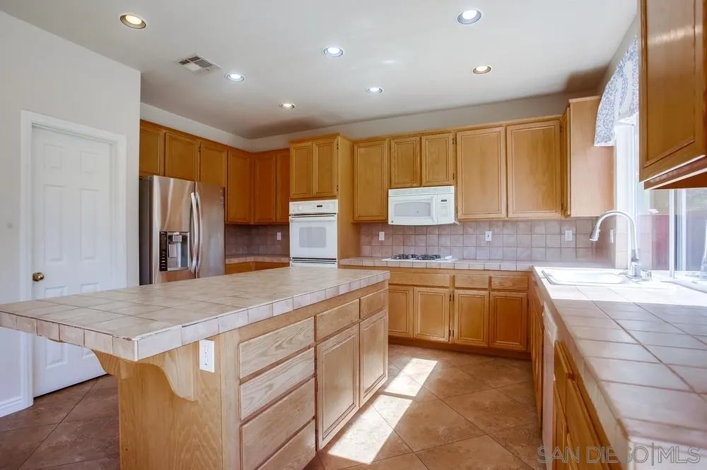 5163 Riverview Court Fallbrook, CA 92028 - Photo 12 of 75 a kitchen with stainless steel appliances granite countertop a sink and a stove