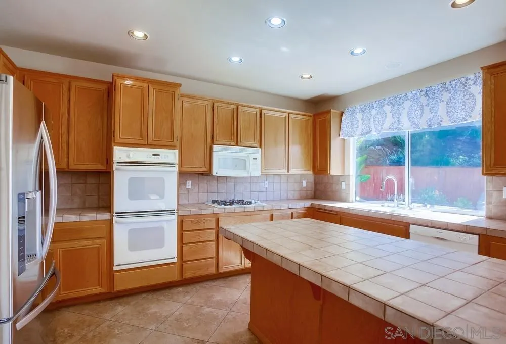 5163 Riverview Court Fallbrook, CA 92028 - Photo 13 of 75 a kitchen that has a lot of cabinets in it and stainless steel appliances