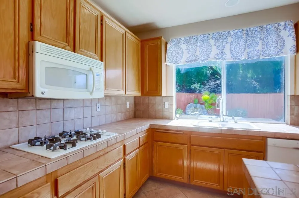 5163 Riverview Court Fallbrook, CA 92028 - Photo 14 of 75 a kitchen with a sink stove and cabinets