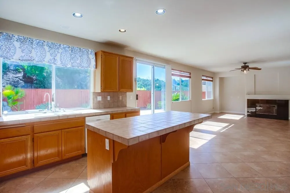 5163 Riverview Court Fallbrook, CA 92028 - Photo 15 of 75 a kitchen with a stove a sink a counter top space and living room view