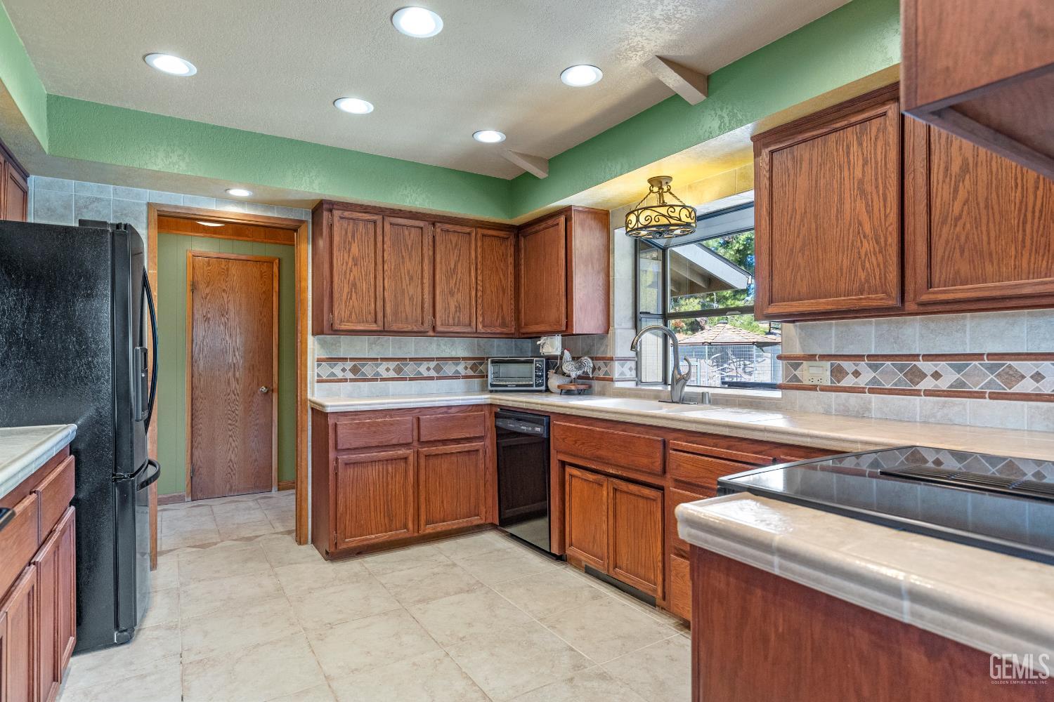Undisclosed Address Tehachapi, CA 93561 - Photo 19 of 58 a kitchen with sink a refrigerator and wooden cabinets