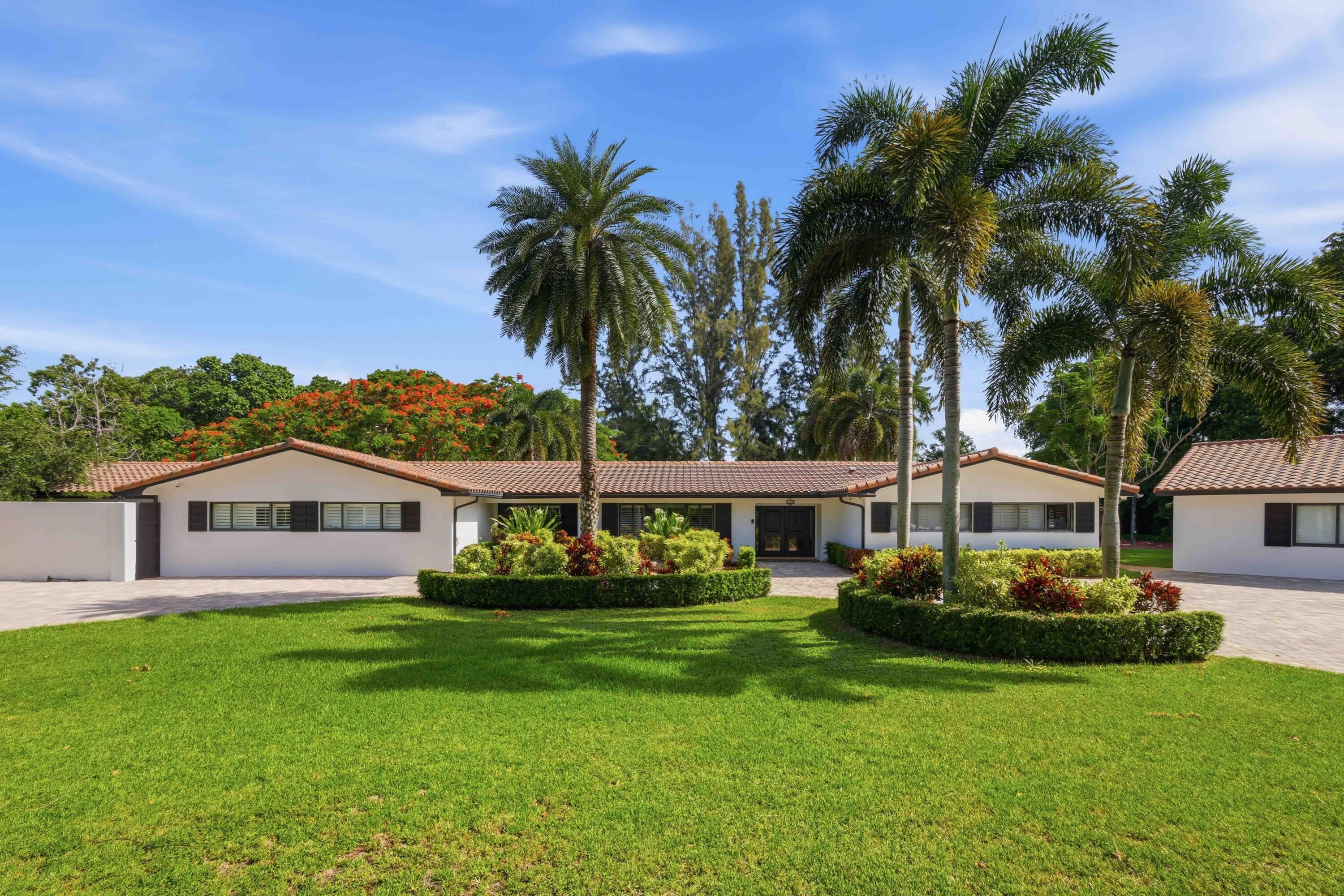 14701 Southwest 63rd Street Southwest Ranches, FL 33330 - Photo 4 of 50 a front view of a house with a garden and lake view