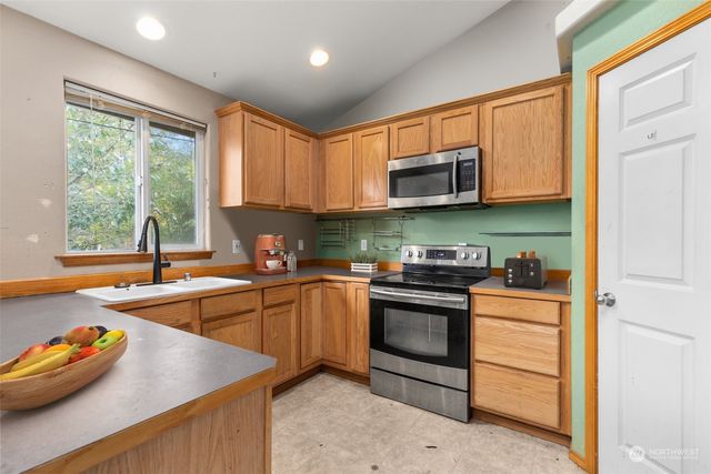 a kitchen with stainless steel appliances granite countertop a sink stove and cabinets