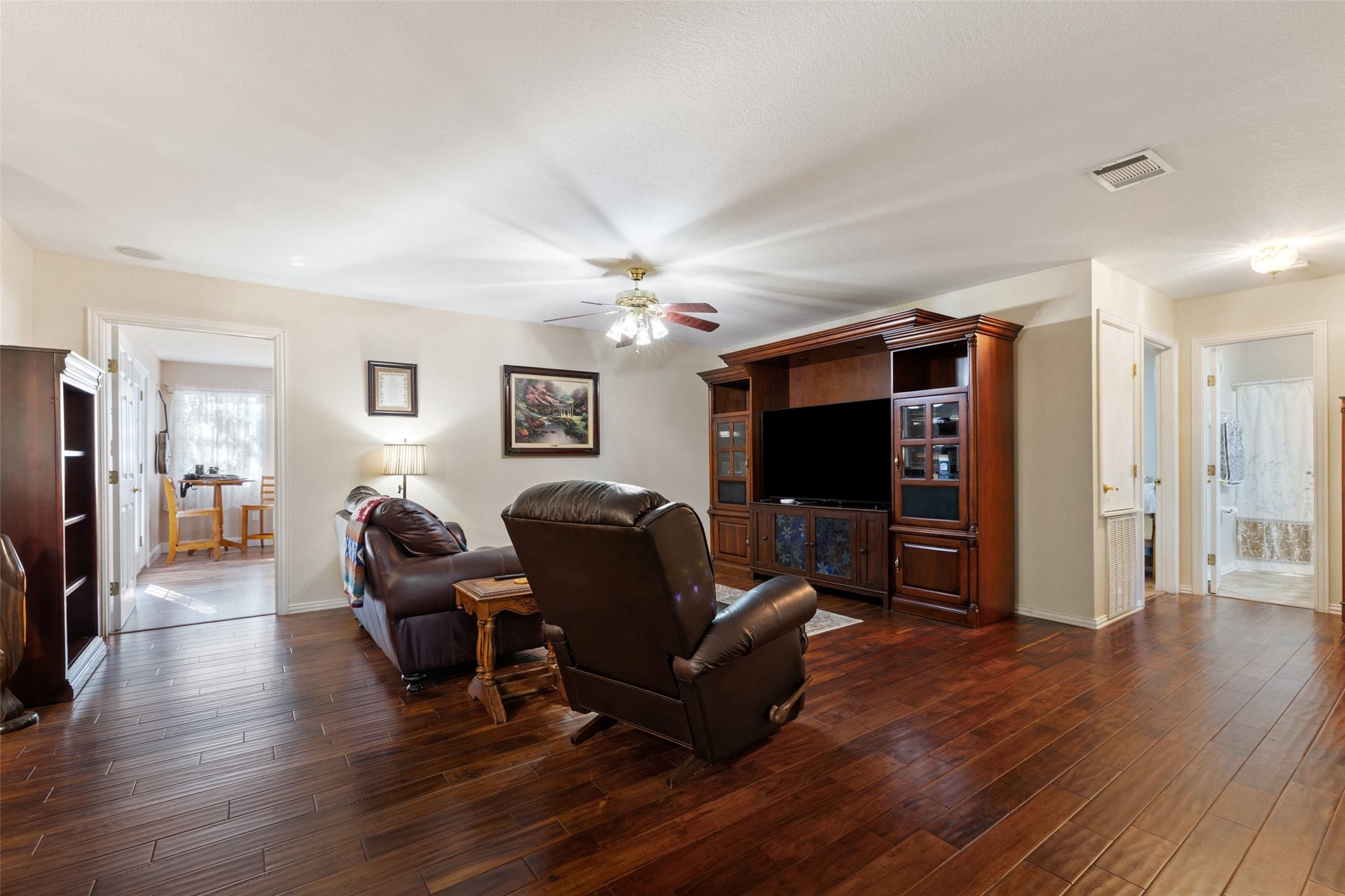 399 Upper Elgin River Road Elgin, TX 78621 - Photo 21 of 39 Living room with a ceiling fan and dark wood flooring