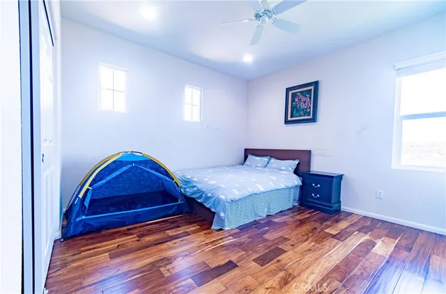 a bedroom with a bed and wooden floor