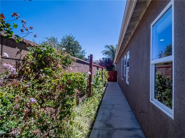 a view of a swimming pool with a yard and a wooden fence
