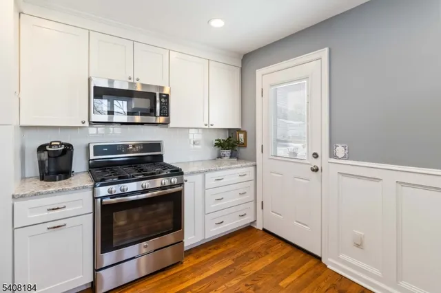 a kitchen with stainless steel appliances white cabinets and a stove top oven