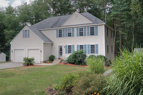 a front view of a house with a yard and potted plants