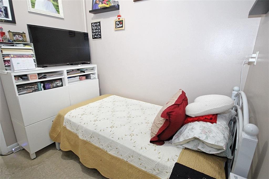 6018 4th Avenue Brooklyn, NY 11220 - Photo 11 of 15 a bedroom with a bed and flat screen tv