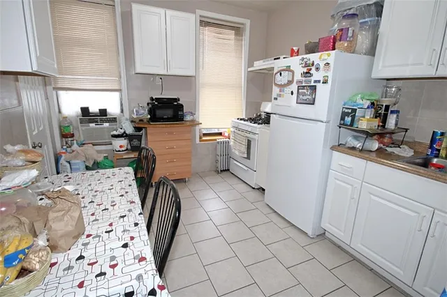 a kitchen with a refrigerator and white cabinets