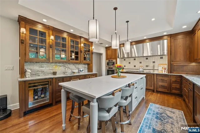 a kitchen with stainless steel appliances granite countertop a stove a sink dishwasher and a refrigerator with wooden floor