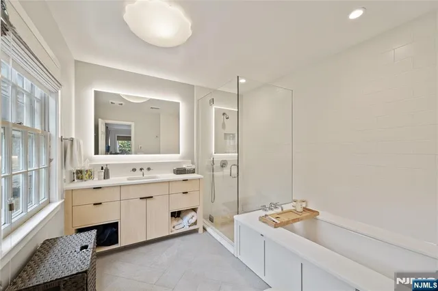 a bathroom with a tub sink and mirror