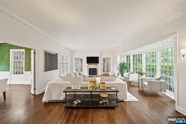 a living room with furniture large window and wooden floor