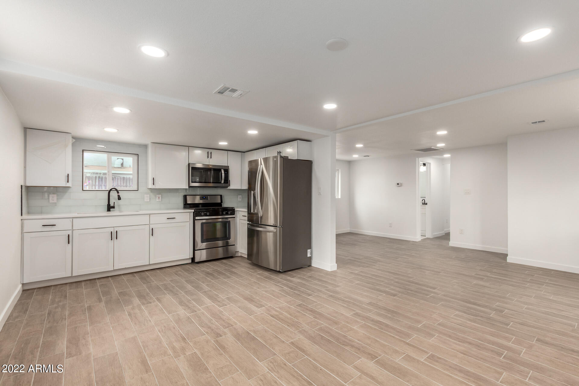 9619 North 12th Avenue Phoenix, AZ 85021 - Photo 5 of 24 a large kitchen with stainless steel appliances granite countertop a stove a sink and a refrigerator