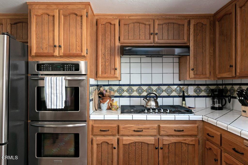 5000 Dolphin Way Oxnard, CA 93035 - Photo 23 of 56 a kitchen with granite countertop a stove a microwave and cabinets
