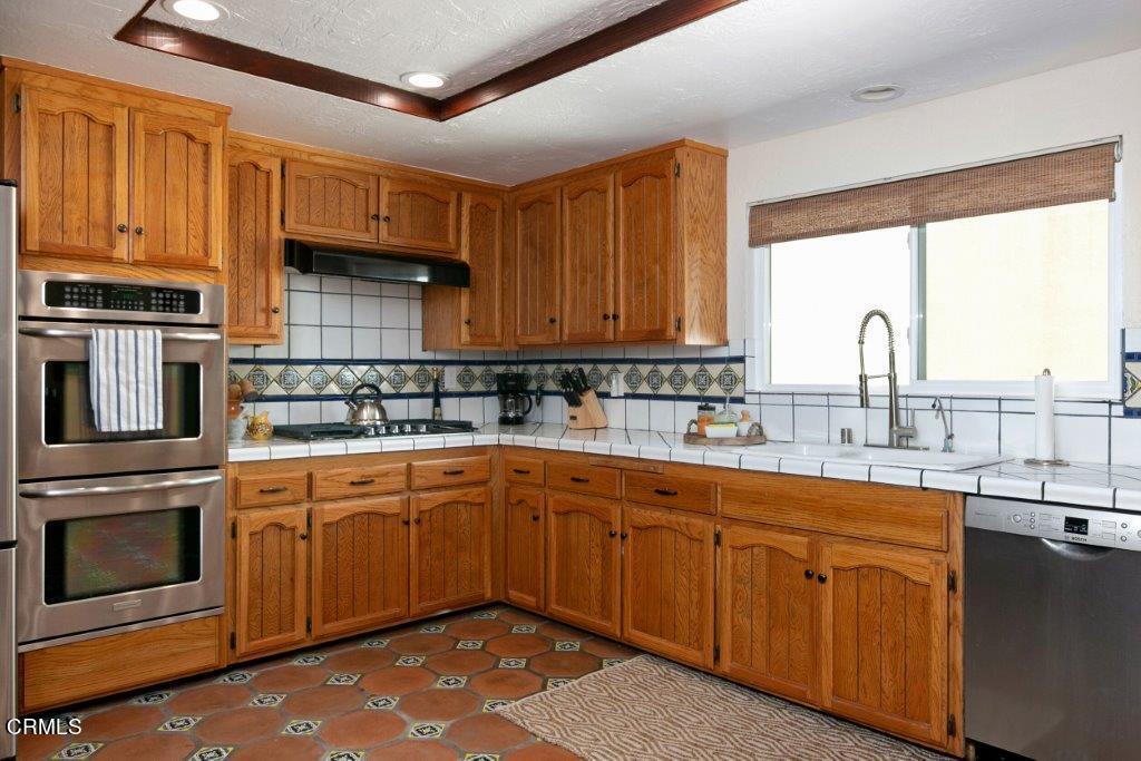 5000 Dolphin Way Oxnard, CA 93035 - Photo 25 of 56 a kitchen with kitchen island granite countertop a sink stainless steel appliances and cabinets