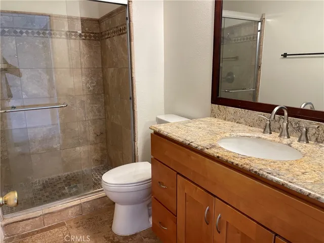 a bathroom with a granite countertop sink toilet and shower